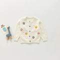 Children's white cardigan with floral embellishments on a light grey background