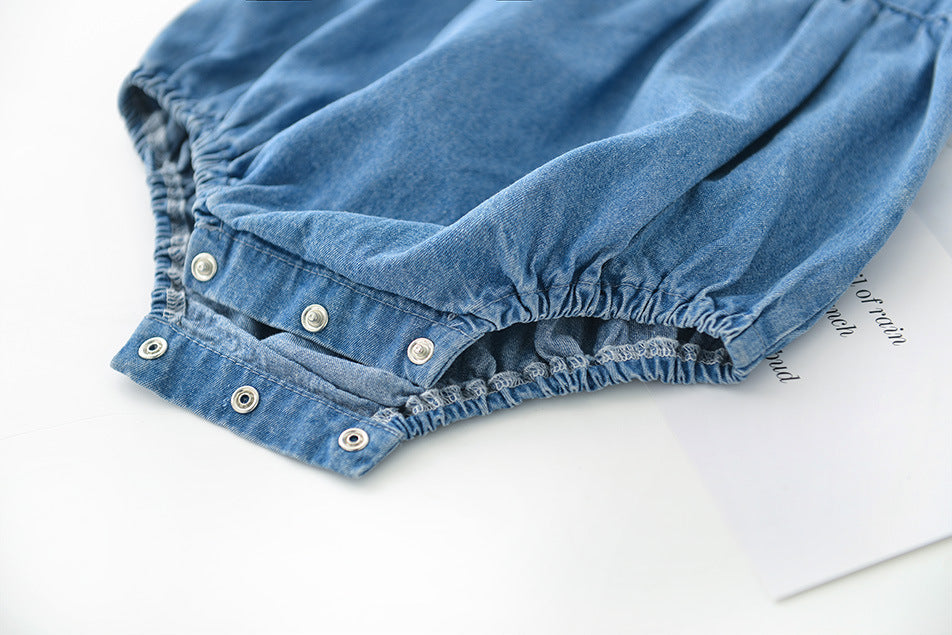 Close-up of blue girls denim bloomers with button details on a white background
