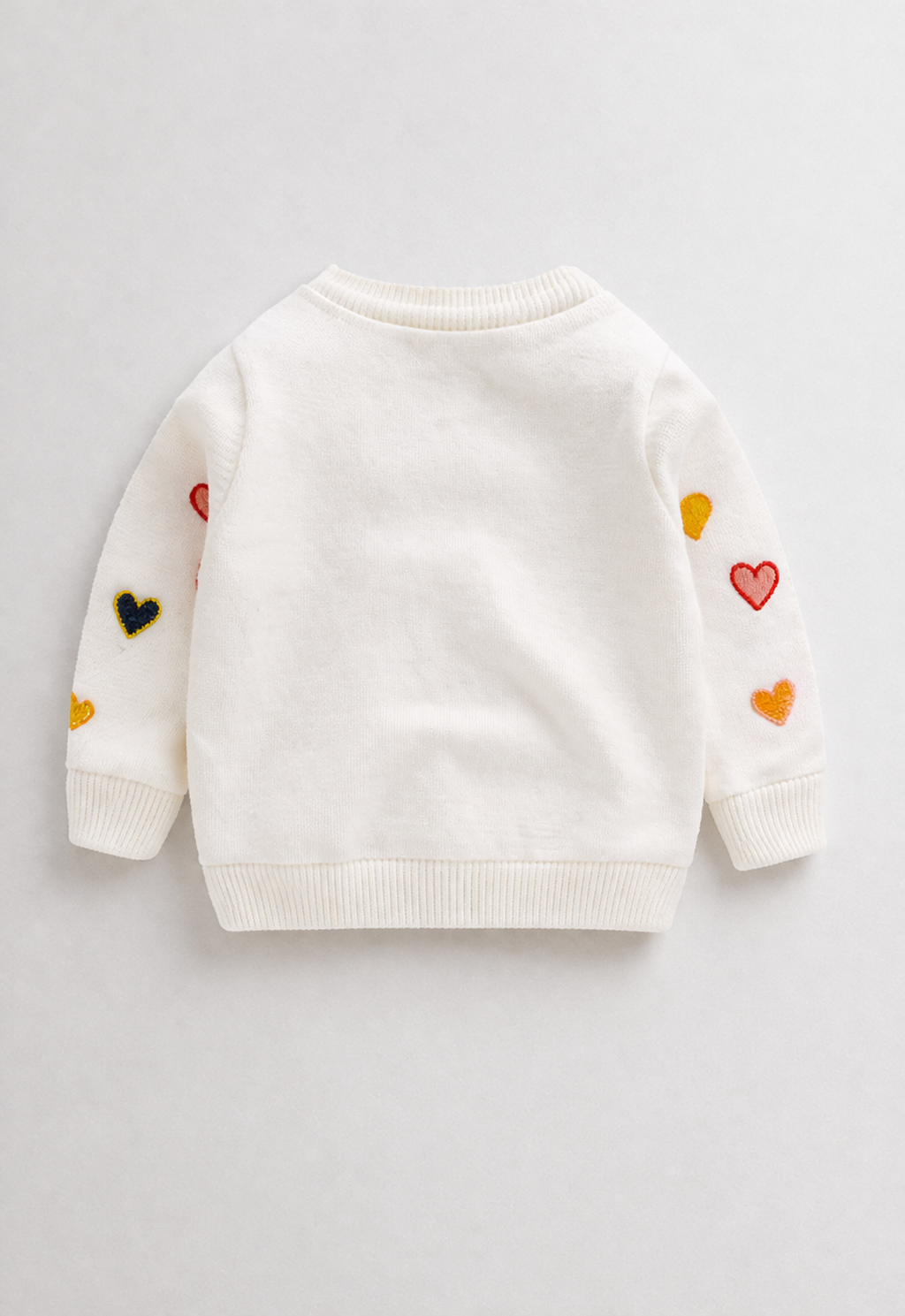 White sweater with colorful heart patterns on a white background