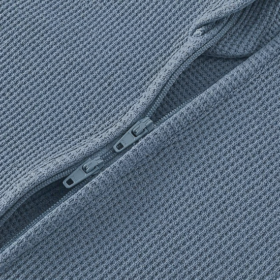 Blue baby onesie on a beige background with a green leaf