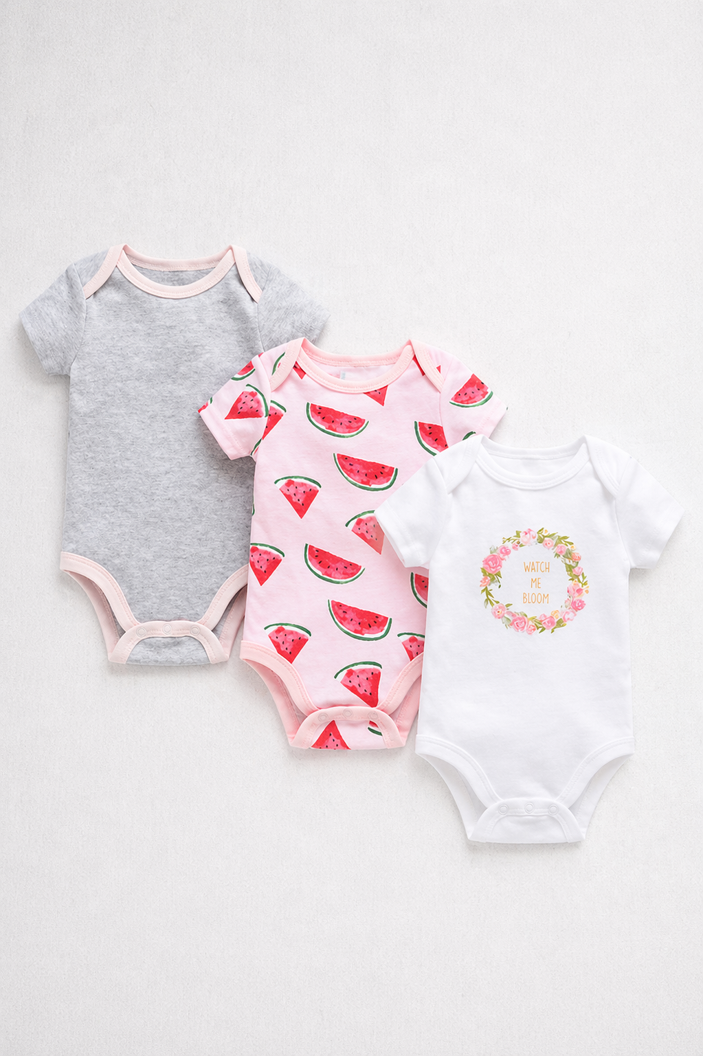 Three baby bodysuits with watermelon designs on a white background