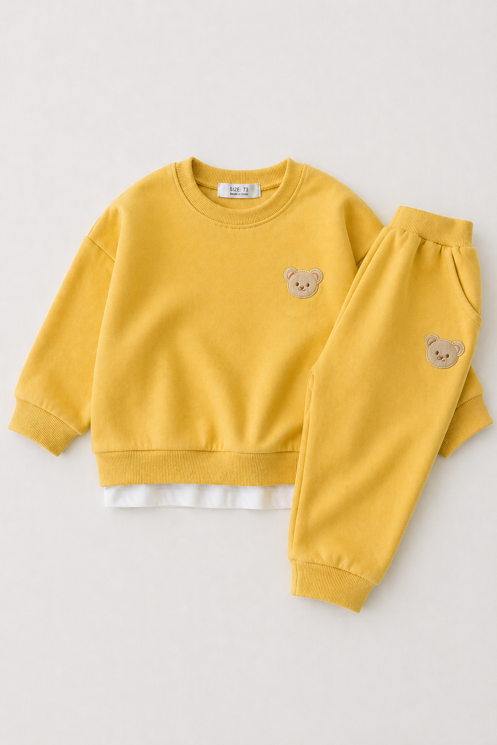 Yellow children's sweatshirt and pants set with bear designs on a white background
