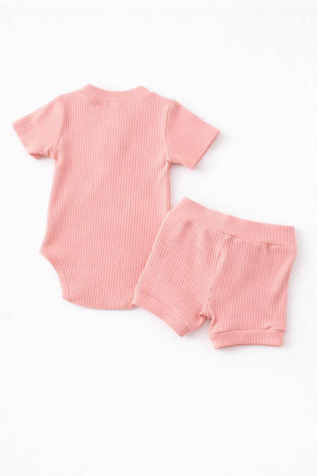 Pink baby outfit with short-sleeve top and shorts on a white background