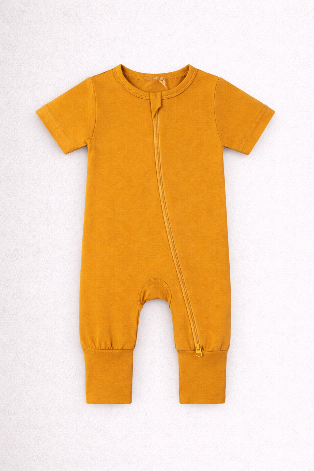 Mustard yellow baby onesie with a zipper on a white background