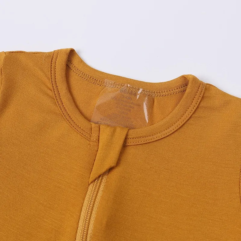 Close-up of a mustard yellow sleeveless top with a clear label on a white background